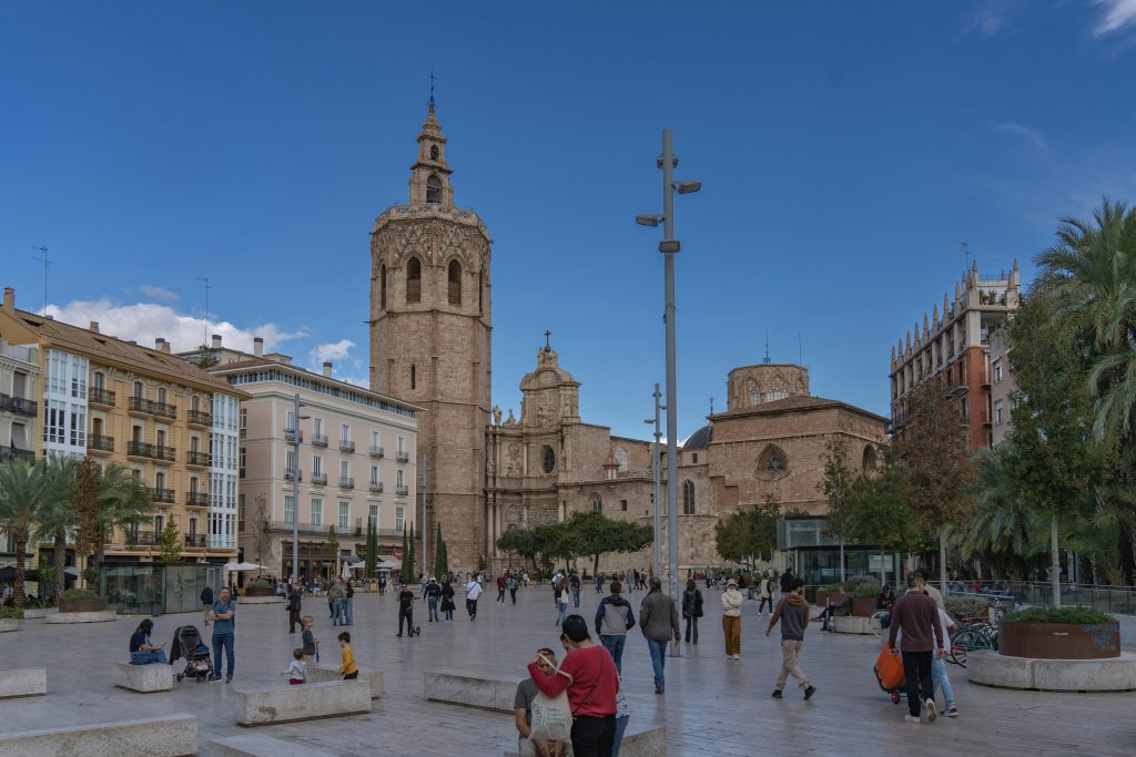 Captivating view of Valencia Cathedral against a clear sky in a bustling city square.